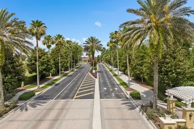 an empty street with palm trees on either side at Windsor Hills Condo: Water Park Included in Orlando