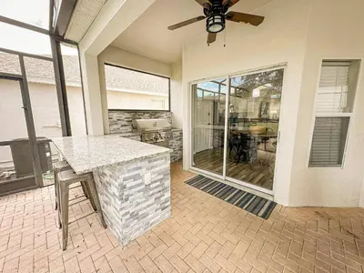 a living room with a table and a large window at Family Fun 6BR Poolside w Water Park Game Room in Orlando
