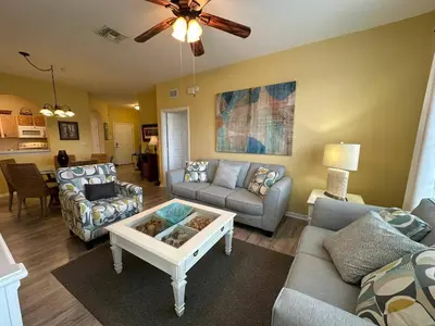 a living room with a couch and a table at Delight Condo Water Park Near Disney Parks in Orlando