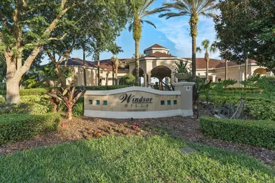 a sign in front of a house with palm trees at Elegant Getaway Windsor Hills Condo w Water Park in Orlando