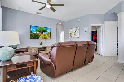 a living room with a couch and a ceiling fan at Family Fun Haven: Spacious Villa Water Park in Orlando