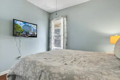 a bedroom with a bed and a tv on the wall at Family Fun Haven: Spacious Villa Water Park in Orlando