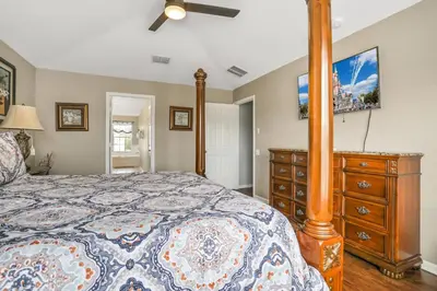 a bedroom with a bed with a dresser and a tv at Family Fun Haven: Spacious Villa Water Park in Orlando