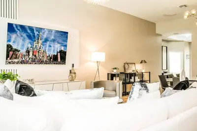 a living room with white furniture and a painting on the wall at Family-Friendly Villa Resort: Free Water Park in Orlando