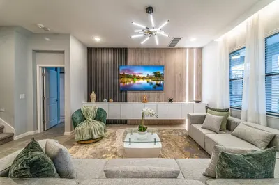 a living room with a couch and a tv at Luxury Meets Adventure 8BR Condo with Themed Rooms in Orlando