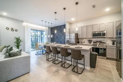 a kitchen with a large island with bar stools at Luxury Meets Adventure 8BR Condo with Themed Rooms in Orlando