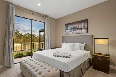 a bedroom with a large bed and a large window at Elegant Escape: 4BR Villa near Disney Views in Orlando
