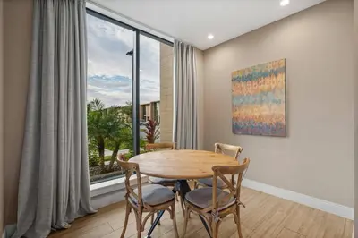 a dining room with a table and chairs and a large window at Elegant Escape: 4BR Villa near Disney Views in Orlando