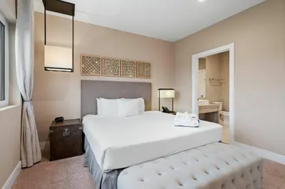 a bedroom with a large white bed and a bathroom at Elegant Escape: 4BR Villa near Disney Views in Orlando