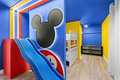 a childs room with a blue and yellow wall with a slide at Group Getaway Paradise: Large Home Water Park in Orlando