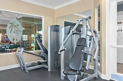 a gym with two tread machines and a mirror at Windsor Hills Getaway: Condo with Water Park in Orlando