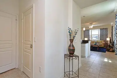 a vase with flowers on a stand in a living room at Family Paradise 4BR Compass Bay Townhome Sleeps 11 in Kissimmee