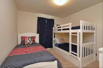 a small bedroom with two bunk beds and a bed at Family Paradise 4BR Compass Bay Townhome Sleeps 11 in Kissimmee