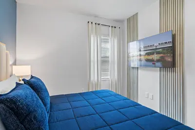 a bedroom with a blue bed and a flat screen tv at Kids Dream Vac Home Harry Potter Mickey Rooms in Orlando