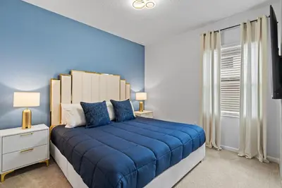 a blue bedroom with a large bed with blue sheets at Kids Dream Vac Home Harry Potter Mickey Rooms in Orlando