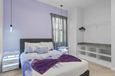 a bedroom with a bed with a purple blanket on it at Unforgettable Vacation: 9BR Paradiso Grand Resort in Orlando