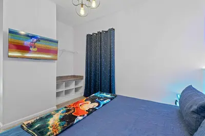 a bedroom with a blue bed and a window at Unforgettable Vacation: 9BR Paradiso Grand Resort in Orlando