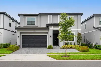a large white house with a garage at Paradiso Grand Resort 6 bedroom in Orlando