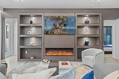 a living room with a fire place in the wall at Luxury Living: 6BR Condo near SeaWorld ICON Park in Orlando