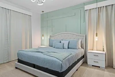 a bedroom with a large bed with blue walls at Luxury Living: 6BR Condo near SeaWorld ICON Park in Orlando