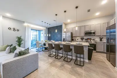 a kitchen and living room with a couch and a table at Themed Retreat 6BR w Magical Rooms Private Pool in Orlando