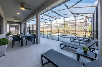 a conservatory with tables and chairs on a patio at Themed Retreat 6BR w Magical Rooms Private Pool in Orlando
