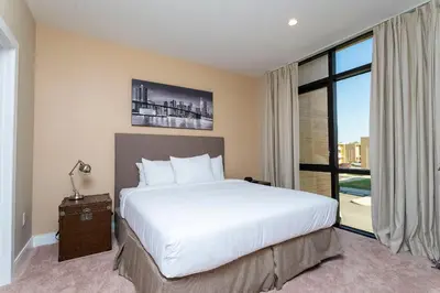 a bedroom with a large bed and a large window at Casa 3Q c/ Área de Churrasco – Próx. Disney in Orlando