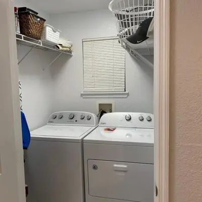 a laundry room with a washing machine and a window at Villa del Sol in Kissimmee