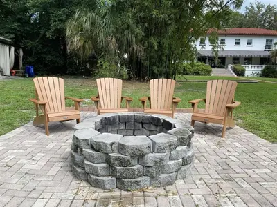 a group of three chairs sitting around a fire pit at 6 Bedroom Historic Home in Orlando