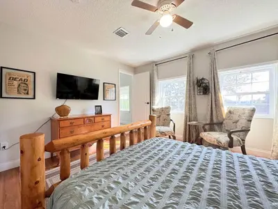 a bedroom with a bed and a flat screen tv at 6 Bedroom Historic Home in Orlando