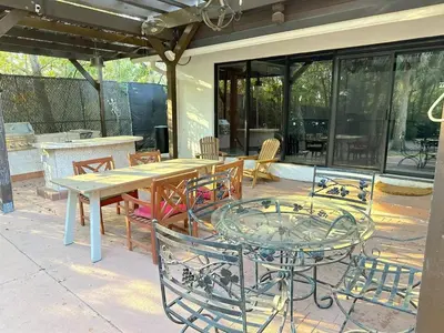 a patio with a wooden table and chairs at Themed Speak Easy with Pool, Hot Tub, & Lake in Orlando
