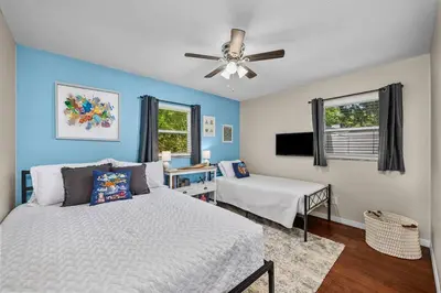 a bedroom with a bed and a ceiling fan at New Design-Movie Night Bar-Fire Pit-Hammocks-Games in Orlando