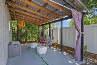 a pergola with a swing in a backyard at New Design-Movie Night Bar-Fire Pit-Hammocks-Games in Orlando