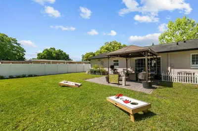 a backyard with two ping pong tables in the grass at New Design-Movie Night Bar-Fire Pit-Hammocks-Games in Orlando