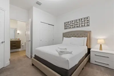 a white bedroom with a bed and a lamp at Casa 3Q c/ Piscina Privativa – Refúgio Familiar in Orlando