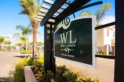 a sign for a hotel with palm trees in the background at Corner Villa in West Lucaya – Your Ideal Getaway in Kissimmee
