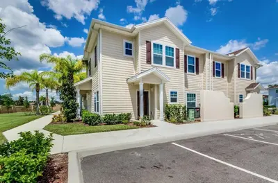a large white house with a parking lot at Corner Villa in West Lucaya – Your Ideal Getaway in Kissimmee