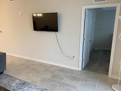 a room with a flat screen tv on a wall at Comfortable 2BR Condo w/ Lake Views in Kissimmee