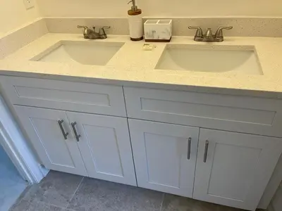 a bathroom with two sinks and white cabinets at Grand Luxury 3BR Penthouse near Disney Parks in Kissimmee