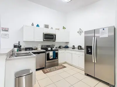 a kitchen with stainless steel appliances and white cabinets at The Galactic Getaway, 3Bed, 2Bath Apartment, Free Parking, Heated Pool in Kissimmee