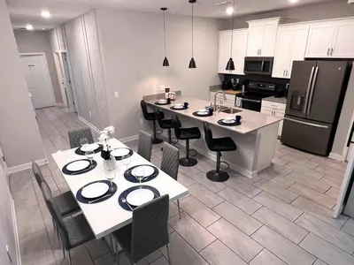 a kitchen with a table and chairs and a refrigerator at Spacious 5BR Villa w/ Private Pool Near Disney & Orlando! in Kissimmee