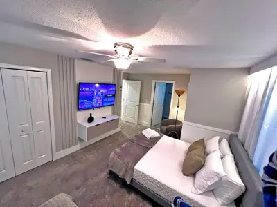 a bedroom with a bed and a flat screen tv at Spacious 5BR Villa w/ Private Pool Near Disney & Orlando! in Kissimmee