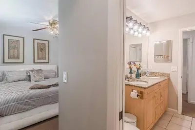 a bedroom with a bed and a bathroom with a sink at Large Deck, Lakefront, Yard Games in Orlando