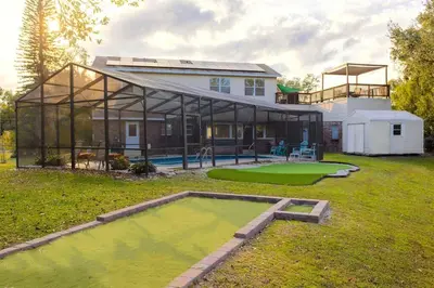 a large house with a pool in the yard at 4 Rooms, Lake, Pool, Hot Tub, Bocce Ball, Putting in Orlando