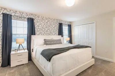 a bedroom with a white bed and a window at Beautiful Storey Lake Retreat Minutes from Disney in Kissimmee