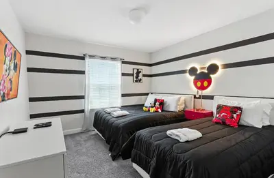 two beds in a room with black and white stripes at Beautiful Storey Lake Retreat Minutes from Disney in Kissimmee