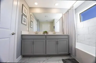 a bathroom with a sink and a tub and a mirror at Stunning 4Bd Close to Disney with Pool at Storey Lake 4369 in Kissimmee