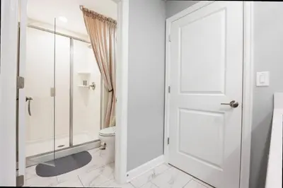 a white bathroom with a shower and a toilet at Stunning 4Bd Close to Disney with Pool at Storey Lake 4369 in Kissimmee