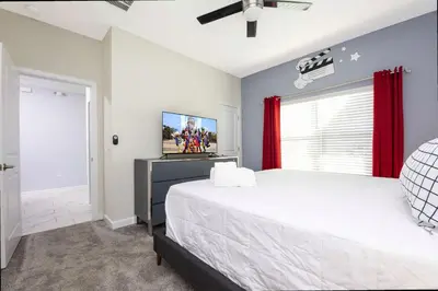 a bedroom with a large bed with red curtains at Stunning 4Bd Close to Disney with Pool at Storey Lake 4369 in Kissimmee