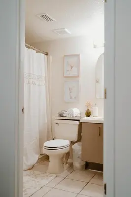 a white bathroom with a toilet and a sink at Luxury Private Pool Villa near Disney with Fire Pit, Game Room & More in Kissimmee